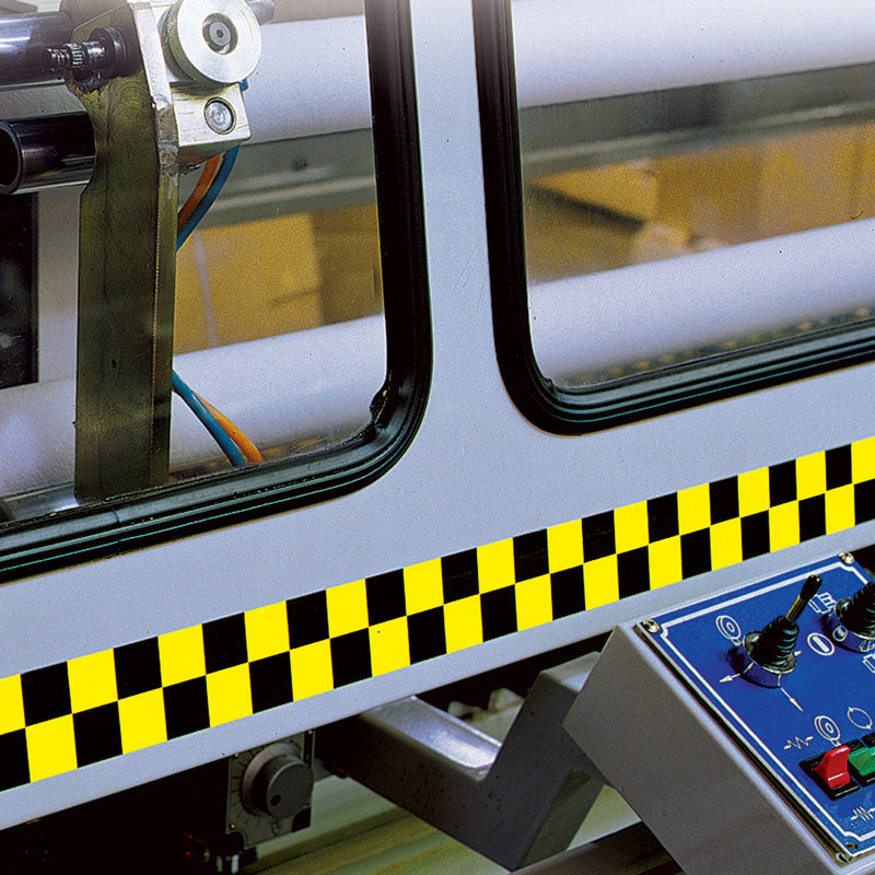 LCB210 Yellow/Black Laminated Adhesive Checkerboard Pattern Marking Tape (54 ft) Applied to the safety cover on a piece of machinery