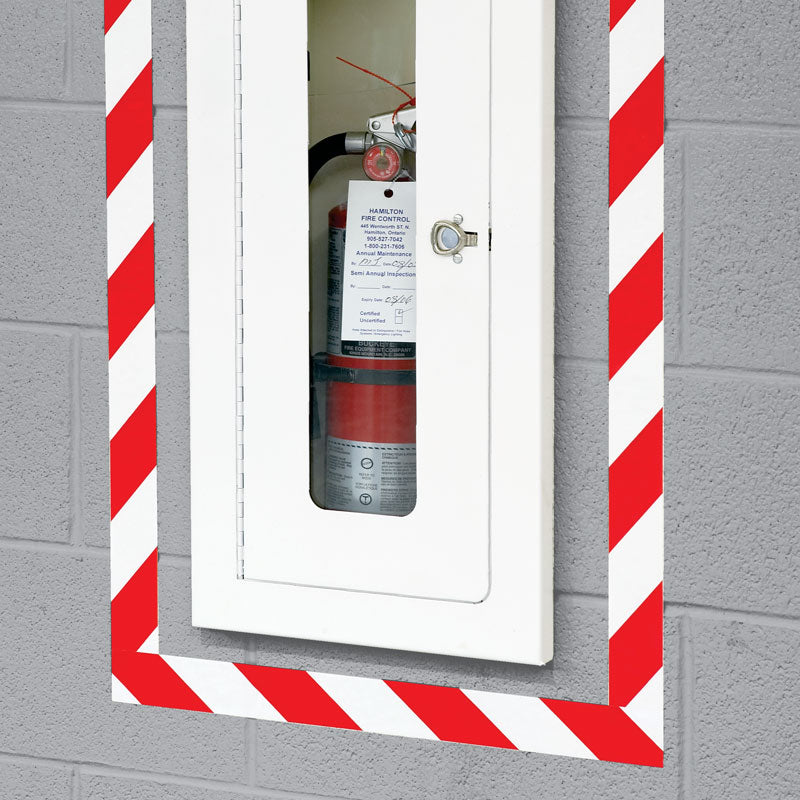 LWT211 Red/White Laminated Adhesive Hazard Stripe Marking Tape (54 ft) on a wall outlining a fire extinguisher
