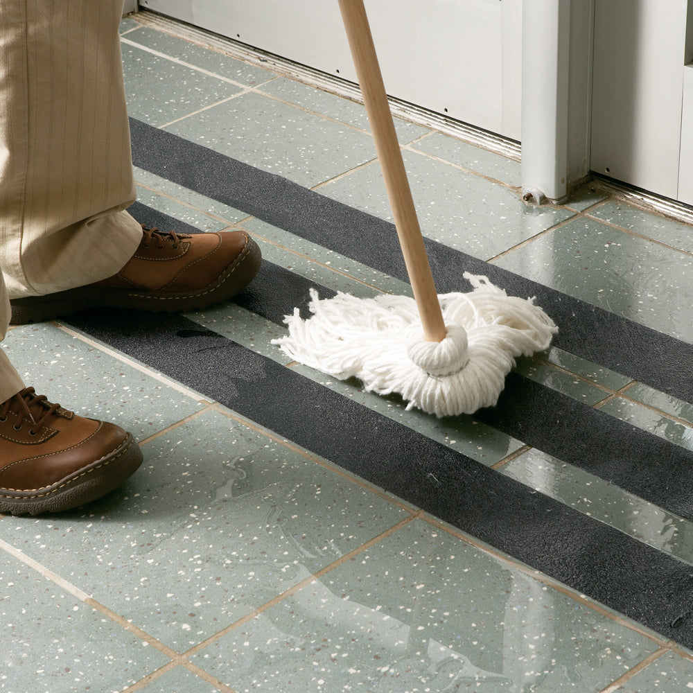 SG5102MB Gator Grip® Mopper's Friend Black Mop Friendly Roll Anti-Slip Grip Traction Tape (2 in x 60 ft) being cleaned with a dry mop