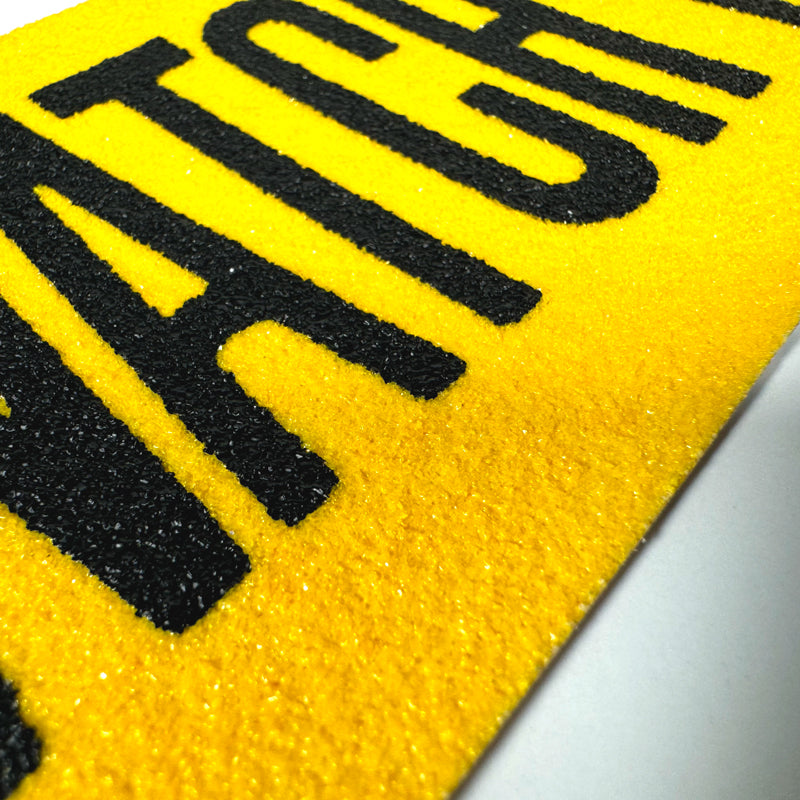SG8903PT Gator Grip® Premium Worded Print WATCH YOUR STEP Yellow/Black Anti-Slip Grip Roll 60-grit Traction Tape (3 in x 60 ft) Close up of print